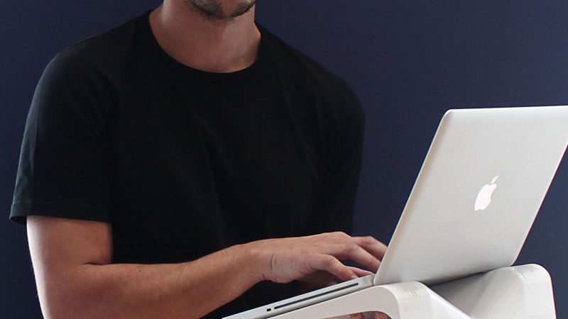 Close up of a man holding a laptop